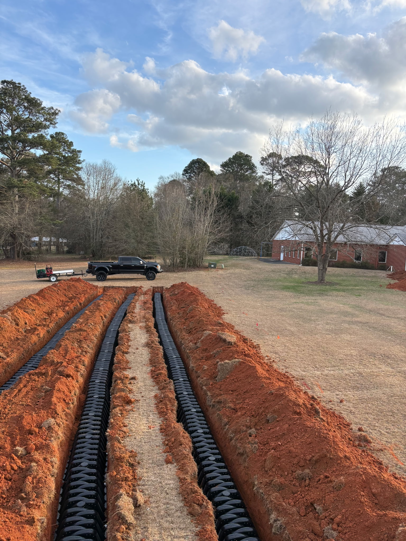 Sanders Septic LLC drain field installation in Loganville Georgia showing black chamber rows in red Georgia clay